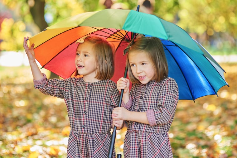 twins-looking-for-shelter-with-umbrella-5L53NKK